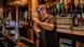 A pub barman pulls a pint while wearing a face visor A pub barman pulls a pint while wearing a face visor