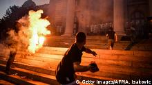 Protesters clash with police in front of Serbia's National Assembly building in Belgrade on July 8, 2020 during a demonstration against a weekend curfew announced to combat a resurgence of COVID-19 infections despite Serbia's president said today it might be scrapped after the measure sparked the day before angry protests that ended in clashes with police. - Chaotic scenes rocked Belgrade on July 7 at night after thousands of people streamed into the city centre to protest the president's announcement that authorities would reimpose a round-the-clock weekend lockdown. Around 20 people were arrested and dozens were injured in running battles between police, who used tear gas, and protesters who stormed into parliament, threw rocks at officers and were accused of setting police cars alight. (Photo by ANDREJ ISAKOVIC / AFP) (Photo by ANDREJ ISAKOVIC/AFP via Getty Images)