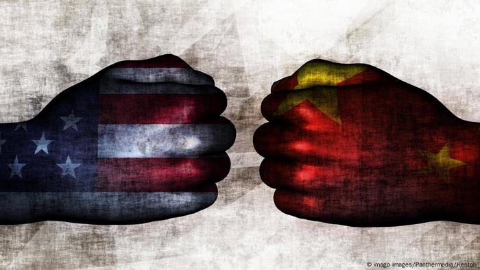 Два повернутых друг к другу кулака: один раскрашен как флаг США, второй - как флаг КНР