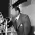 Robeson, a singer, actor and activist, speaks in front of a microphone.