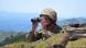 Ein armenischer Soldat schaut an der Frontlinie durch ein Fernglas Ein armenischer Soldat schaut an der Frontlinie durch ein Fernglas