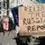 A protester outside Downing Street holding up a sign urging the release of the Russia report