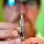 A pharmacist handles a syringe for a vaccine