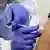 Рука со шприцем во время прививки