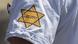 A yellow star with the words 'unvaccinated' on the arm of a protest A yellow star with the words 'unvaccinated' on the arm of a protest