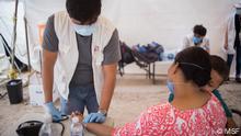 A mother and her son are checked before going to the consultation by the nurse Angel Nuñez in the MSF tent inside the camp.