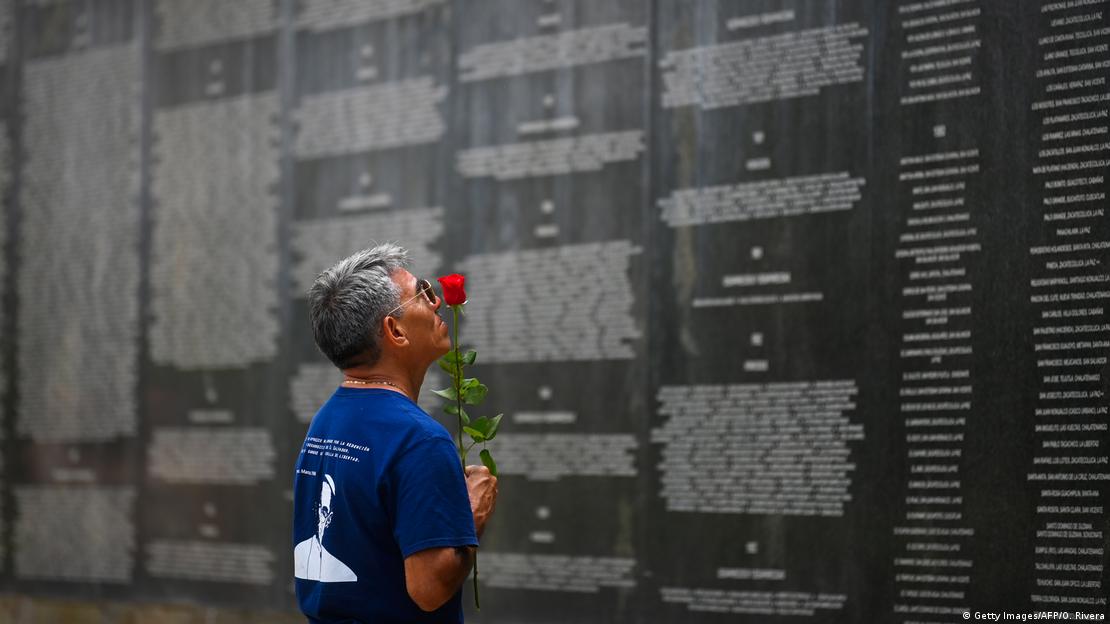 Foto de archivo de una persona frente al monumento de las víctimas de la guerra civil de El Salvador.