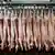 Pig carcasses strung up on hooks