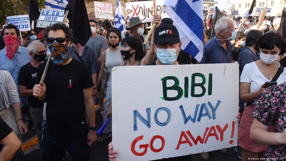 Protesters hold up a sign reading 'Bibi no way go away'