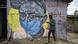 A boy wearing a face mask walks past a mural of a woman with a face mask in a Nairobi slum A boy wearing a face mask walks past a mural of a woman with a face mask in a Nairobi slum
