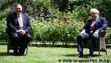US Secretary of State Mike Pompeo (L) and Britain's Prime Minister Boris Johnson sit in socially distanced chairs in the garden of 10 Downing street in central London on July 21, 2020. (Photo by HANNAH MCKAY / POOL / AFP) (Photo by HANNAH MCKAY/POOL/AFP via Getty Images)