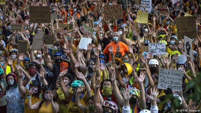 Demonstranten halten vor dem Justice Center in Portland, Oregon, ihre Hände in die Luft 