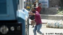 Protesters throw stones at Indian government forces following a gun battle between militants and government forces in Srinagar on May 19, 2020. - Two Kashmir militants including a key rebel leader were killed in a rare 12-hour gun battle in the main city Srinagar on May 19, officials said, sparking clashes between locals and police. (Photo by Tauseef MUSTAFA / AFP)