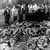 Menschen an einem der freigelegten Massengräber von Katyn. (Foto: dpa)