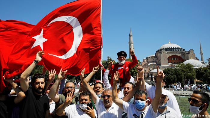 People outside Hagia Sophia Grand Mosque show Grey Wolves hand gesture with Turkish flag