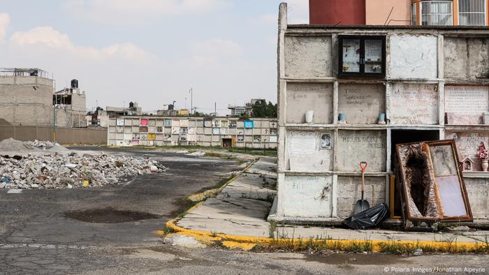 A coffin from one of the mass burial plots lies open as grass grows through the cracks in the streets