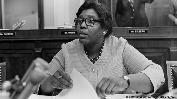 American congresswoman Barbara Jordan sitting at a table with papers in her hand