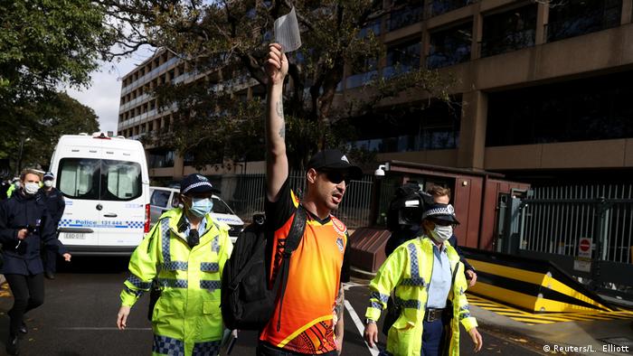 A demonstrator holds up a citation ticket issued by police, after police shut down a rally that was deemed unlawful