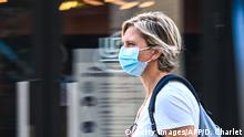 A woman wearing a protective mask walks on a street in Lille, northern France, on July 30, 2020, as The Nord Prefecture announced, the reinforcement of the health measures at a local level to attempt to halt the rising cases of coronavirus Covid-19, which have been seen in the region during the past two weeks. - In a discussion between the French Health Minister, The Nord Prefet and Nord Regional Health Agency director (ARS) on July 29, the possibility of making the wearing of protective masks compulsory outside due to the proximity with Belgium was spoken of in an effort to halt the rise of coronavirus cases. (Photo by DENIS CHARLET / AFP) (Photo by DENIS CHARLET/AFP via Getty Images)