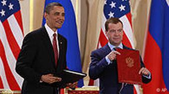 Obama und Medwedew stehen jeweils mit einer Unterschriftsmappe in der Hand vor ihren Landesflaggen (Foto: AP Photo/Alex Brandon)