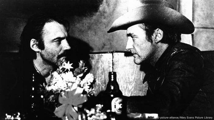 Zwei Männer in einer Kneipe in Gespräch, vorne Blumen und Bier (Bild: picture-alliance/Mary Evans Picture Library)