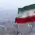 Iran's national flag flies over the skyline of Tehran