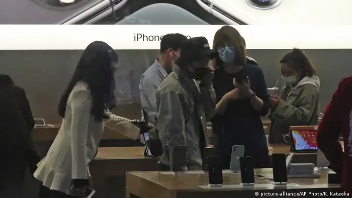 People wearing face mask go out for shopping at Apple Store of a commercial complex in Sanlitun, Beijing
