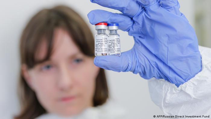 باحثة تحمل عبوات من اللقاح الروسي الجديد