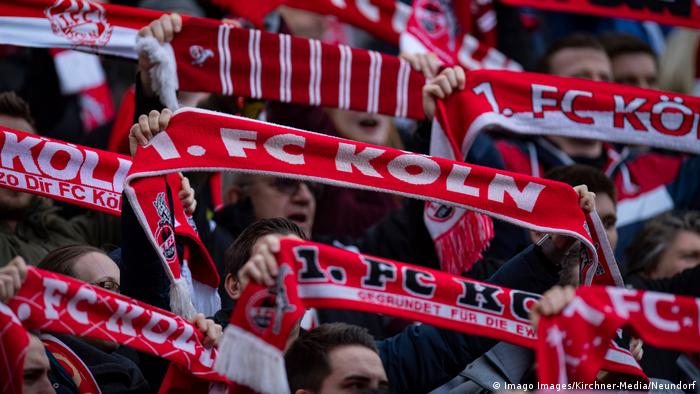 FC Cologne fans hold their scarves aloft