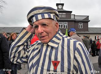 A fromer prisoner stands in front of theBuchenwald concentration camp