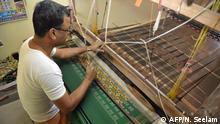 Indian weaver, Vanam Vijay Kumar weaves fabric on a handloom at his household workshop at Koyalagudem village of Nalgonda District, some 50 kilometers from Hyderabad on January 19, 2017. - The southern states of Telangana and Andhra Pradesh are known for handloom work and the weavers of these states are known to manufacture exclusive sarees with intricate and distinctive designs. (Photo by Noah SEELAM / AFP)