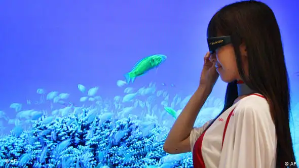 Model in Tokio mit 3D-Brille vor einem Bildschirm, auf dem Fische zu sehen sind (Foto: AP)