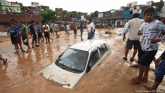 A car partially covered in mud after monsoon rains