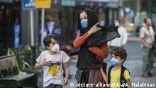 19.07.2020, Iran, Teheran: Kinder mit Gesichtsmasken gehen mit ihrer Mutter eine Straße entlang. Der Iran meldete am 21. Juli eine neue Rekordzahl an Corona-Toten. Foto: Ahmad Halabisaz/XinHua/dpa +++ dpa-Bildfunk +++ |