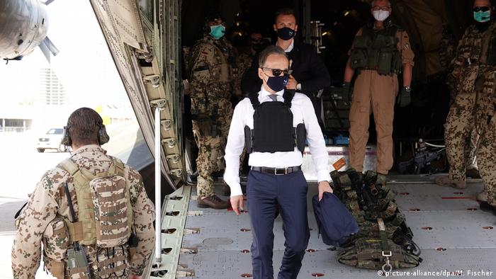 Heiko Maas, masked, leaving plane in Libya