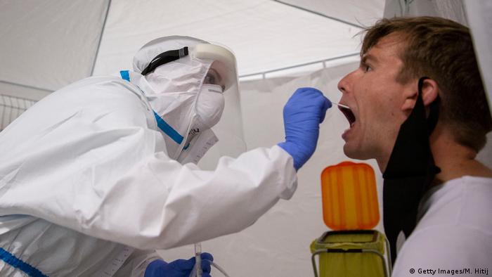 Prueba de antígeno o hisopado: un trabajador de la salud toma una prueba de hisopado a un hombre en la estación central de Berlín.