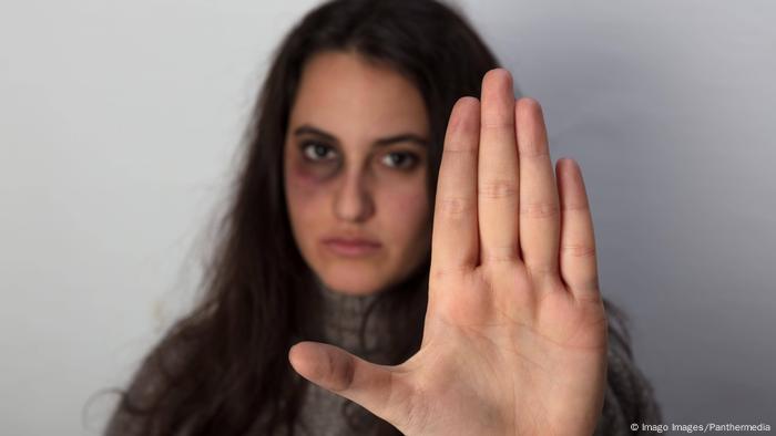 Una mujer golpeada dice basta con la mano: símbolo de la violencia contra las mujeres.