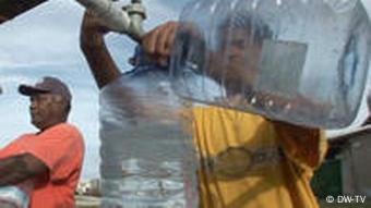 Mann füllt Wasser in Kanister (Quelle: DW)