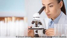 junge konzentrierte frau wissenschaftler mit mikroskop im labor | Verwendung weltweit, Royalty free: Bei werblicher Verwendung Preis auf Anfrage., Keine Weitergabe an Wiederverkäufer.
