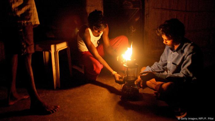 Männer mit Kerosinlampe am Stadtrand von Mumbai 