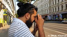 der Fotograf und irakische Geflüchtete Raisan Hameed steht in der Eisenbahnstraße in Leipzig und fotografiert mit seiner Kamera. Datum der Aufnahme: 12.08.2020
Bildrechte: Nader Alsarras/DW
