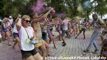 People throw colored powder on each other during the Holi Festival in a city park in Kyiv, Ukraine, Saturday, Aug. 8, 2020. Ukrainians mark a popular ancient Hindu Holi Festival, also known as the festival of colors, or the festival of love, which signifies the victory of good over evil. Normally celebrated in spring, but postponed due to the coronavirus. (AP Photo/Efrem Lukatsky) |