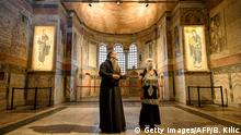 A priest (L) and a woman visit the Chora or Kariye Museum, formally the Church of the Holy Saviour, a medieval Byzantine Greek Orthodox church, on August 21, 2020, in the Fatih district in Istanbul. - Turkish President Recep Tayyip Erdogan on August 21, 2020, ordered another ancient Orthodox church that became a mosque and then a popular Istanbul museum to be turned back into a place of Muslim worship. Located in today's Fatih district in Istanbul, the building was constructed as a monastery in 534 during the Byzantine period. After Istanbul was taken over by the Ottomans in 1453, it was converted into a mosque in 1511, just like Hagia Sophia in Istanbul. Serving as a mosque for 434 years, it was converted into a museum by a Council of Ministers decree in 1945, after the Republic of Turkey was established in 1923. (Photo by BULENT KILIC / AFP) (Photo by BULENT KILIC/AFP via Getty Images)