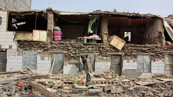 Ein Mann steht zwischen den Trümmern eines eingestürzten Gebäudes (Foto: AP)