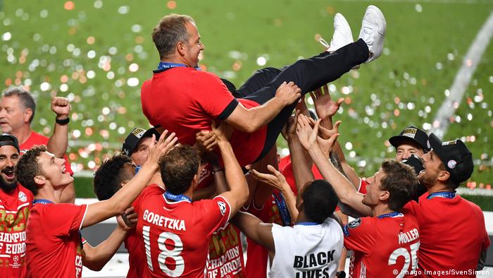 Hansi Flick is lifted aloft by his players.