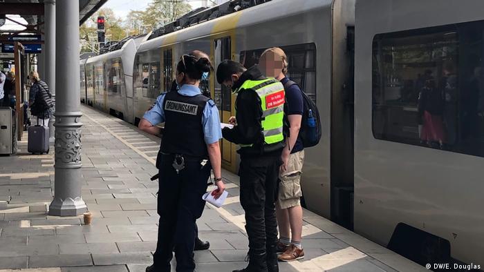 Police hand out a fine to one passenger without a mask