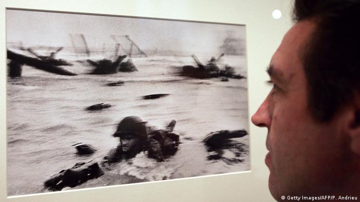 Robert Capas Foto vom Soldaten in der Brandung (Man in the Surf) ist das berühmteste Bild von der alliierten Invasion in der Normandie am 6.6.1944, dem D-Day. Bis heute ist unklar, wer der US-Soldat ist: sowohl Edward Regan als auch Huston Riley haben sich darin erkannt. (Copyright: Getty Images/AFP/P. Andrieu)
