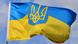 Український синьо-жовтий прапор на тлі синього неба Український синьо-жовтий прапор на тлі синього неба