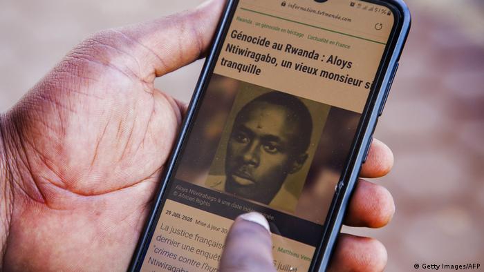 An old image of Aloys Ntiwiragabo, on the smartphone of a Rwandan man reading the news on French outlet TV5. August 26, 2020.