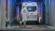 Film still from Ai Weiwei's 'Coronation': a person in a protective suit disinfecting an ambulance indoors Film still from Ai Weiwei's 'Coronation': a person in a protective suit disinfecting an ambulance indoors